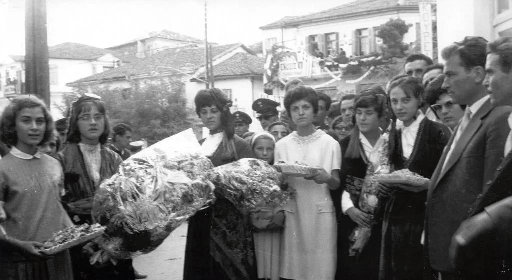 Στην είσοδο της πλατείας κοπέλες με παραδοσιακές στολές έτοιμες να προσφέρουν ανθοδέσμες στον Ανδρέα Παπανδρέου