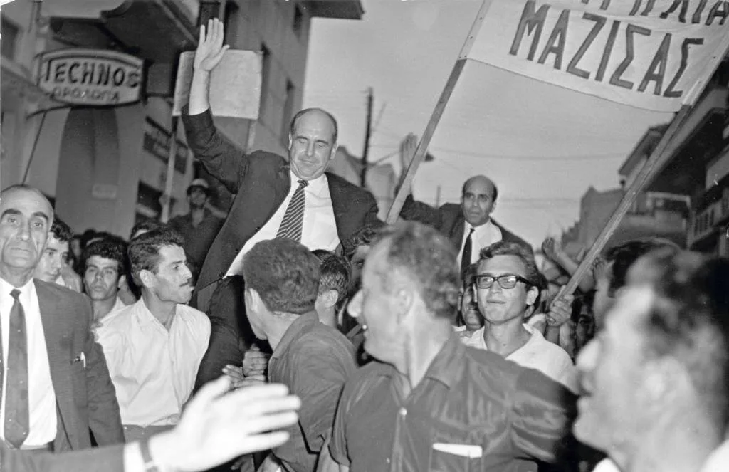 Στην είσοδο των Νέων Μουδανιών οι φίλοι και οι οπαδοί της Ενώσεως Κέντρου σηκώνουν τον Ανδρέα Παπανδρέου και τον Ιωάννη Κυριαφίνη στα χέρια
